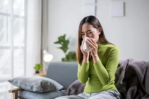 Sho-Me Clean Duct Cleaning—A woman blowing her nose due to the poor air quality in her Branson, MO home.