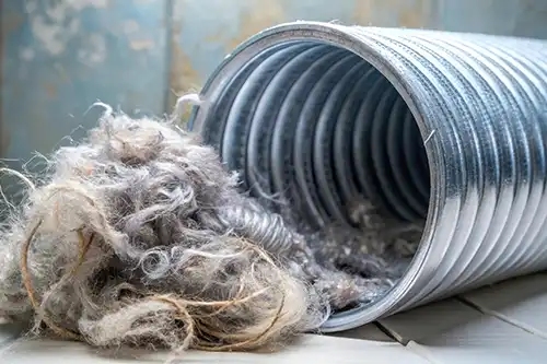 Sho-Me Clean Duct Cleaning—A flexible aluminum dryer vent duct filled with lint in a home in Branson, MO.